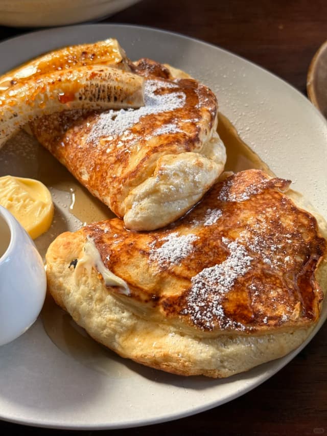 Ricotta hotcakes at Truffles are soft, fluffy, not too sweet, and can be ordered with banana or berries – a delightful Sydney brunch staple.