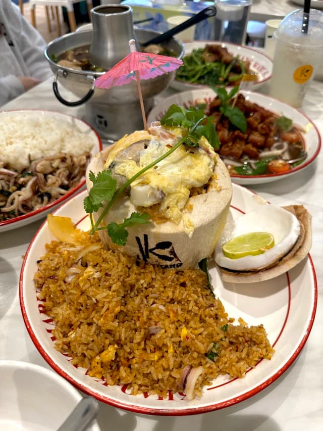 The Tom Yum Coconut Fried Rice is absolutely stunning, served in a whole coconut with authentic Thai flavors that will transport you to Bangkok.